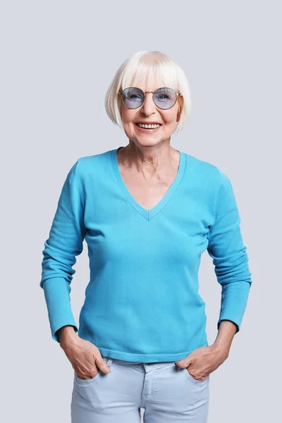 Пожилая Женщина Короткими Седыми Волосами Позирует Сером Фоне Студии Руками — стоковое фото