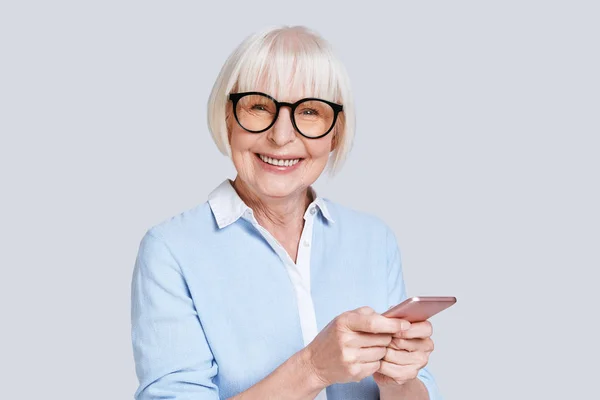 Senior Caucasian Woman Blue Shirt Holding Mobile Phone Looking Camera — Stock Photo, Image