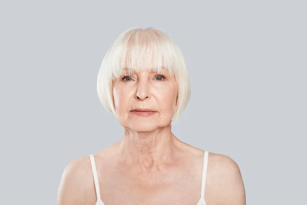 Ernste Seniorin Schaut Weg Und Posiert Vor Grauem Hintergrund Schaut — Stockfoto