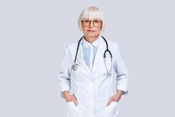 Mujer Médica Senior Seria Con Bata Laboratorio Mirando Cámara Manteniendo — Foto de Stock