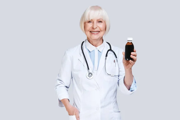 薬の瓶を保持している白衣の年配の女性を笑顔 — ストック写真
