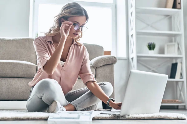 Thoughtful Young Woman Eyewear Working Using Computer While Flooring Home — Stock Photo, Image