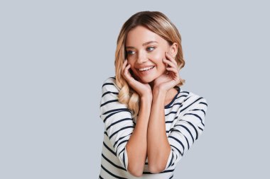 sevimli gülümseyen genç kadın uzak duran gri arka planı arıyorum