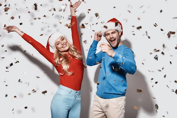 Happy Couple Christmas Hats Dancing Celebrating New Year Confetti Studio — Stock Photo, Image