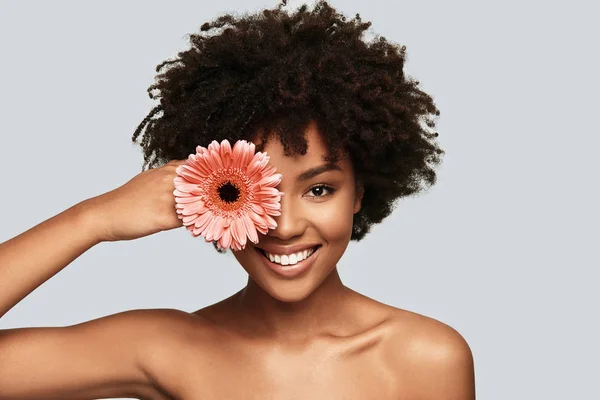 Brünette Afrikanerin Blickt Kamera Und Bedeckt Auge Mit Blume Während — Stockfoto