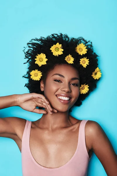 Smiling Young African Woman Yellow Flowers Hair Lying Blue Background — Stock Photo, Image