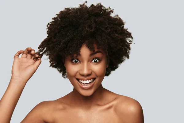 Mujer Africana Feliz Tocándose Pelo Sonriendo Mientras Está Pie Sobre — Foto de Stock