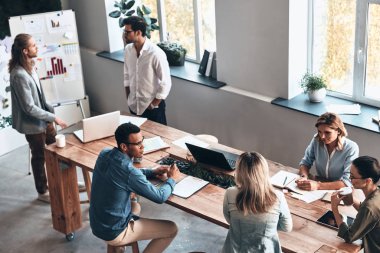 modern ahşap masa dizüstü bilgisayarlar ve kağıtları ile ofiste çalışan iş arkadaşları