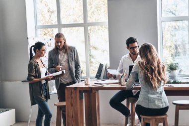 iş insanlar takım poz ve kameraya bakarak yaratıcı modern ofis Studio ahşap masa grupları