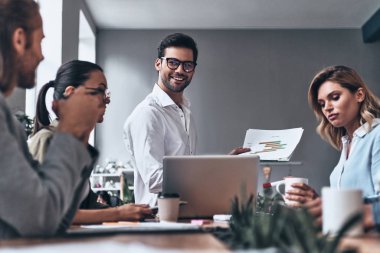 iş adamları yaratıcı modern ofis Studio dizüstü bilgisayar ve kağıtları ahşap masa mutlu Grup 