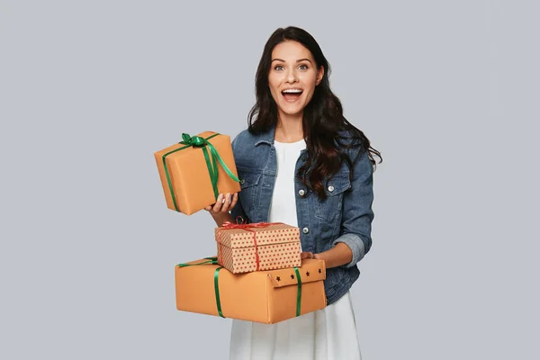 Excited Young Woman Smiling Holding Gift Boxes While Standing Grey — Stock Photo, Image