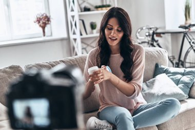 güzellik ürünü test ve sosyal medya video evde yaparken gülümseyen kadın          
