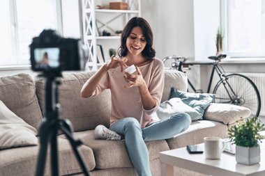 güzellik ürünü test ve sosyal medya video yaparken gülümseyen güzel genç kadın             