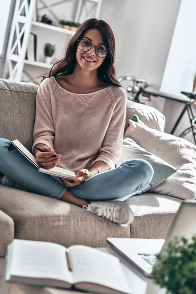 Mooie Jonge Vrouw Glazen Studeren Terwijl Zittend Bank Thuis Bedrijf — Stockfoto