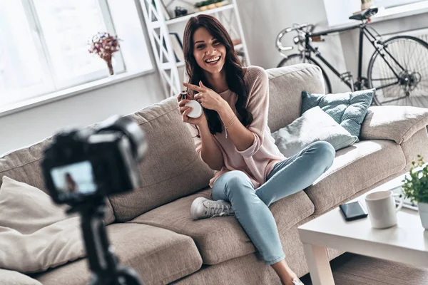 Hermosa Mujer Joven Sosteniendo Productos Belleza Sonriendo Mientras Hace Video —  Fotos de Stock