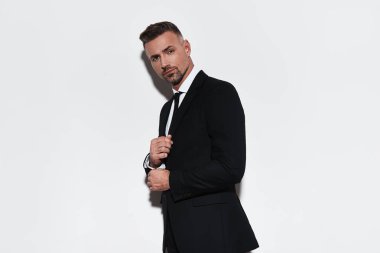 Kol ayarlama ve uzak duran beyaz arka planı arıyorum tam takım elbiseli şık adam