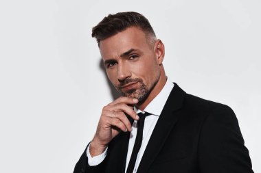 Çene ve gülümseyerek kameraya bakarak Genç ve kendinden emin yakışıklı adam tutmak el 