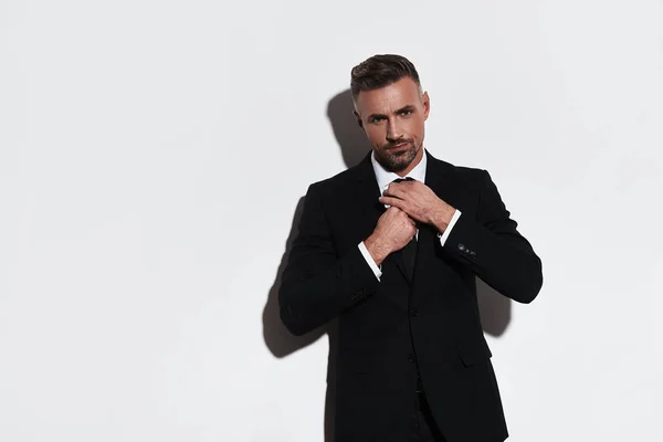 Confident Businessman Adjusting Necktie Looking Camera While Standing White Background — Stock Photo, Image