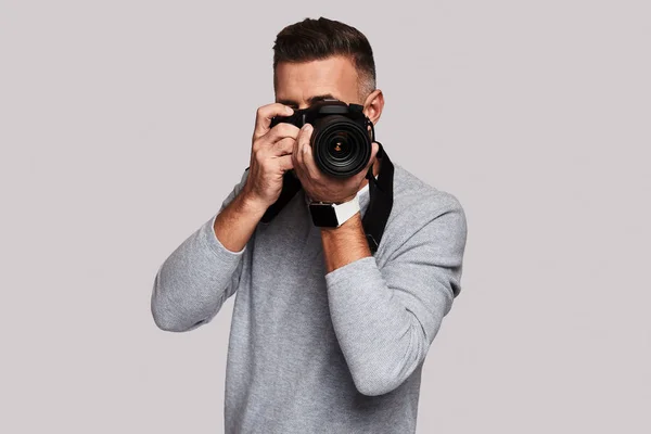 Hombre Fotografiándote Mientras Estás Pie Sobre Fondo Gris —  Fotos de Stock