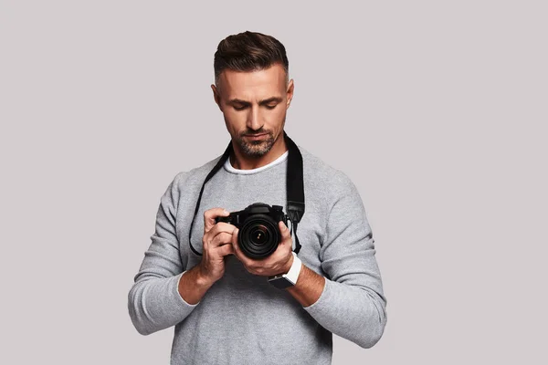 Vertrouwen Fotograaf Holding Digitale Camera Terwijl Staande Tegen Grijze Achtergrond — Stockfoto