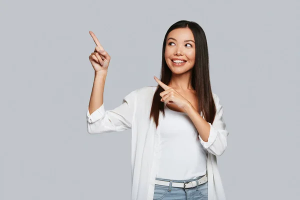 Mooie Jonge Aziatische Vrouw Aanwijsapparaat Kopie Ruimte Glimlachen Terwijl Staande — Stockfoto