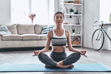 güzel genç Asyalı kadın spor giyim yoga evde dinlenirken yaparken        