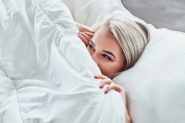 Atractiva Mujer Joven Cubriendo Mitad Cara Con Manta Sonriendo Mientras — Foto de Stock