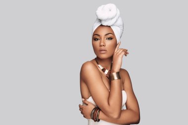 Şehvetli güzellik. Çekici Afrikalı kadın kamera gri arka plan karşı dururken bakarak türban