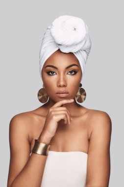 Gurur. Çekici Afrikalı kadın türban el çene duran gri arka plan karşı korumak