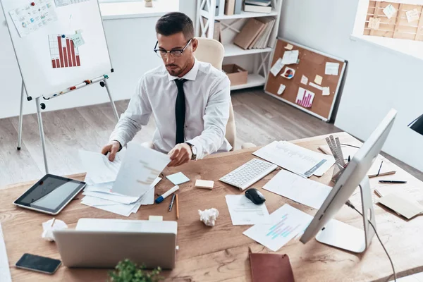 Documenti Uomo Affari Che Cerca Statistiche Tra Documenti Mentre Siede — Foto Stock