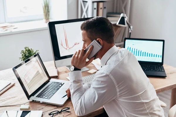 Affärsman Som Pratar Mobiltelefon Vid Bord Med Bärbar Dator Och — Stockfoto