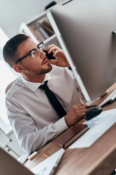 Ouvindo Requisitos Dos Clientes Jovem Sério Falando Telefone Celular Enquanto — Fotografia de Stock