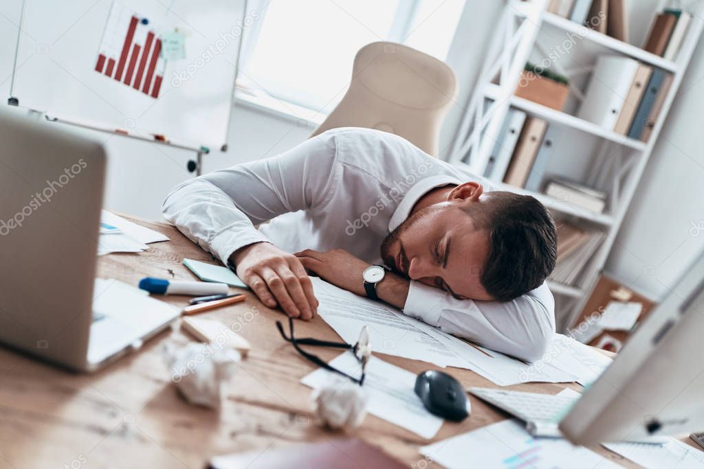 Overworked, Tired businessman sleeping on desk office 