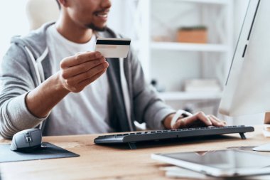 Casual giyim yapım satın online evde kredi kartı ve bilgisayar ile masada otururken dostum