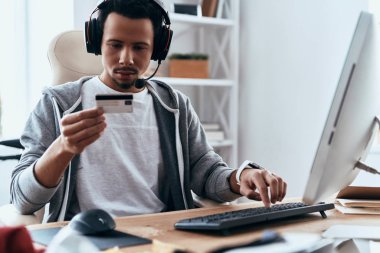 Casual giyim yapım satın online evde kredi kartı ve bilgisayar ile masada otururken dostum