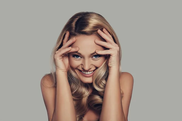 Blonde Junge Frau Berührt Gesicht Mit Händen Und Lächelt Während — Stockfoto