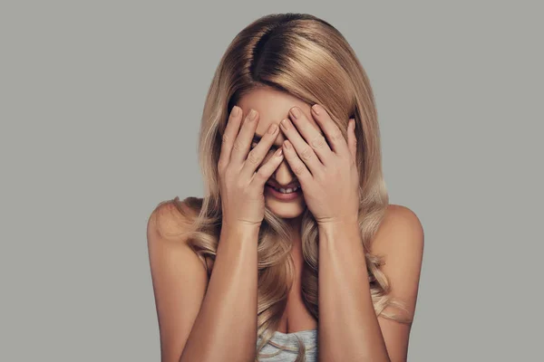 Mujer Rubia Cubriendo Cara Con Las Manos Sonriendo Mientras Está — Foto de Stock