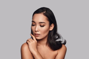 Onun omuz gri arka plan karşı duran el ile dokunmak fevkalade şehvetli, güzel genç bir kadın