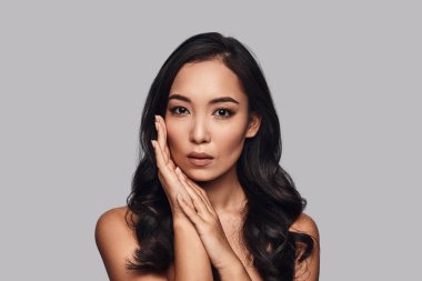 Yumuşak duygusallık, güzel genç kadın kamera gri arka plan karşı dururken bakarak