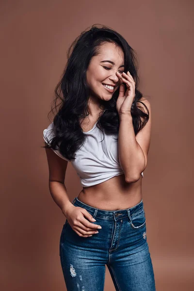 Naturally beautiful, Beautiful young woman smiling and keeping eyes closed while standing against brown background