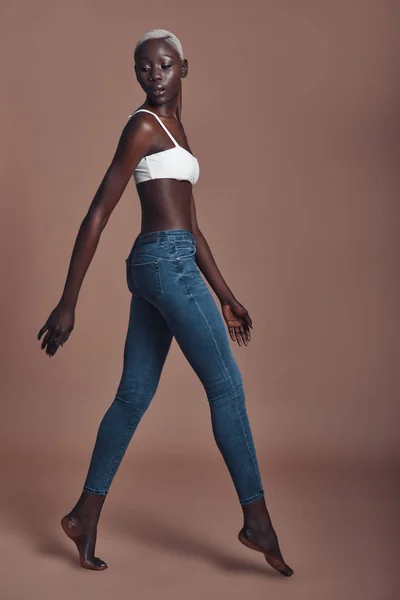 Afrikaanse Vrouw Zoek Weg Tijdens Het Lopen Tegen Bruine Achtergrond — Stockfoto