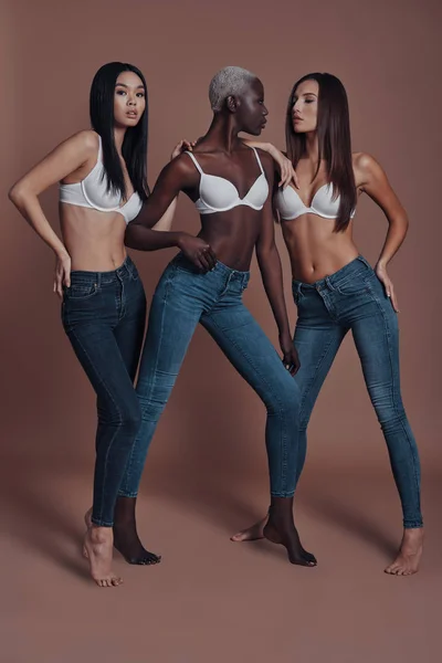 Drei Attraktive Junge Frauen Posieren Voller Länge Vor Braunem Hintergrund — Stockfoto