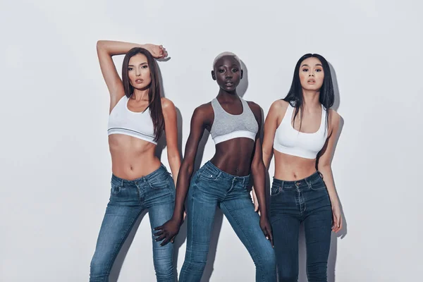 Três Jovens Mulheres Atraentes Olhando Para Câmera Enquanto Contra Fundo — Fotografia de Stock