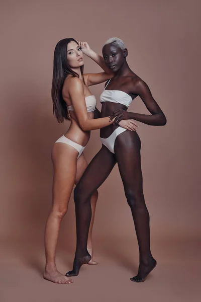 Duas Mulheres Modelos Posando Lingerie Contra Fundo Marrom — Fotografia de Stock