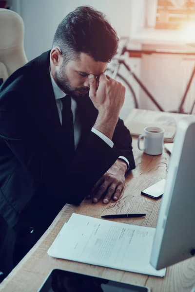 Trött Ung Man Formalwear Massera Näsa Medan Sitter Kontoret — Stockfoto