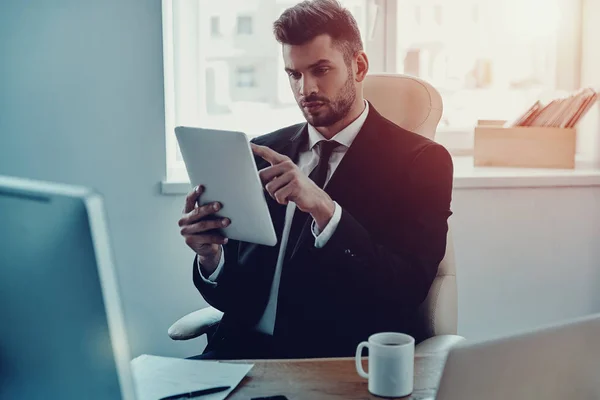 Joven Reflexivo Desgaste Formal Usando Tableta Digital Mientras Está Sentado — Foto de Stock