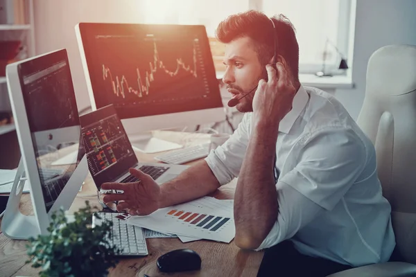 Jovem Empresário Fone Ouvido Conversando Com Cliente Enquanto Está Sentado — Fotografia de Stock