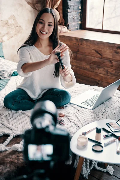 アドバイスを与える ソーシャルメディアビデオを作りながら メイクブラシを持ち 笑顔を持つ美しい若い女性のトップビュー — ストック写真