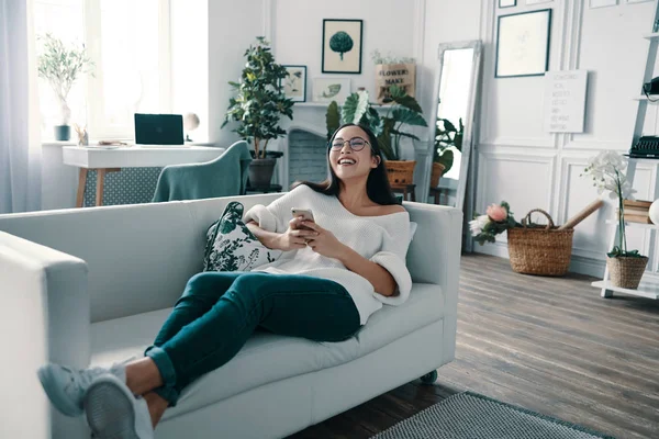 Algo Gracioso Hermosa Mujer Joven Sosteniendo Teléfono Inteligente Riendo Mientras — Foto de Stock