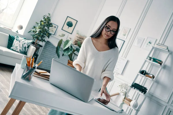 ホームオフィスで作業中にノートパソコンを使用して 美しい若い女性 — ストック写真